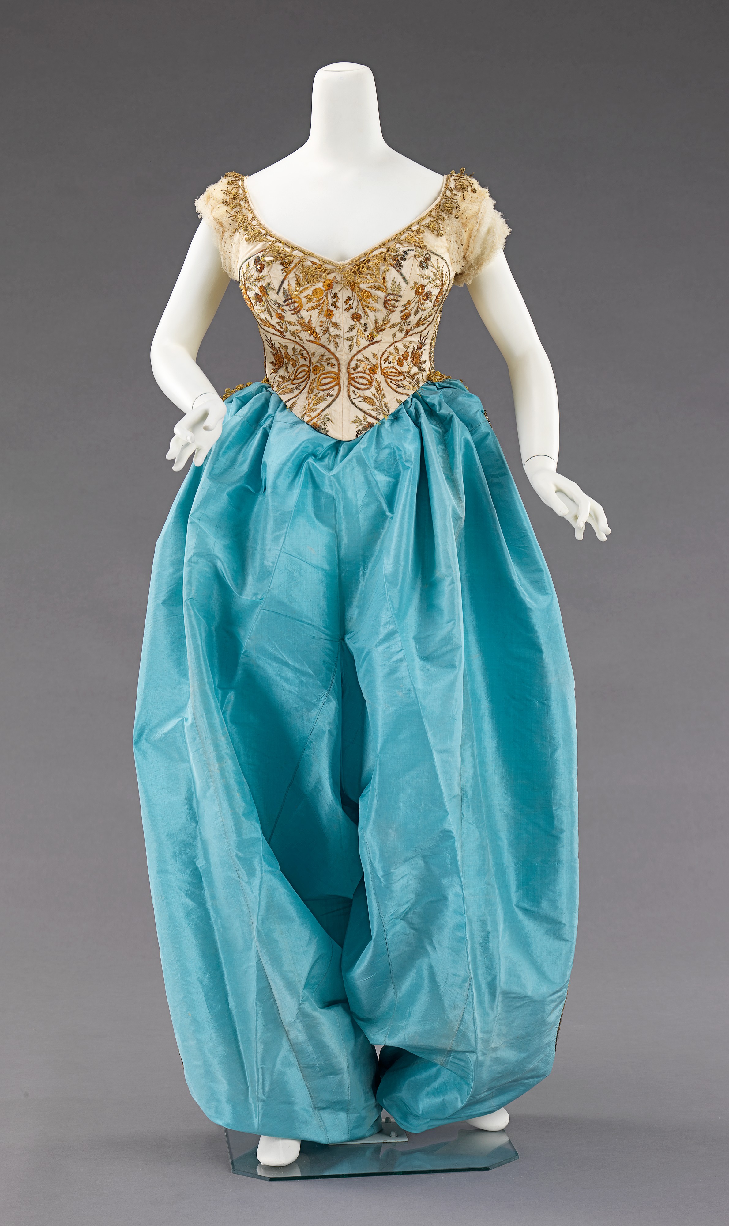 House of Worth fancy dress costume from about 1870, with a fitted bodice, full skirt, and metal ornament.