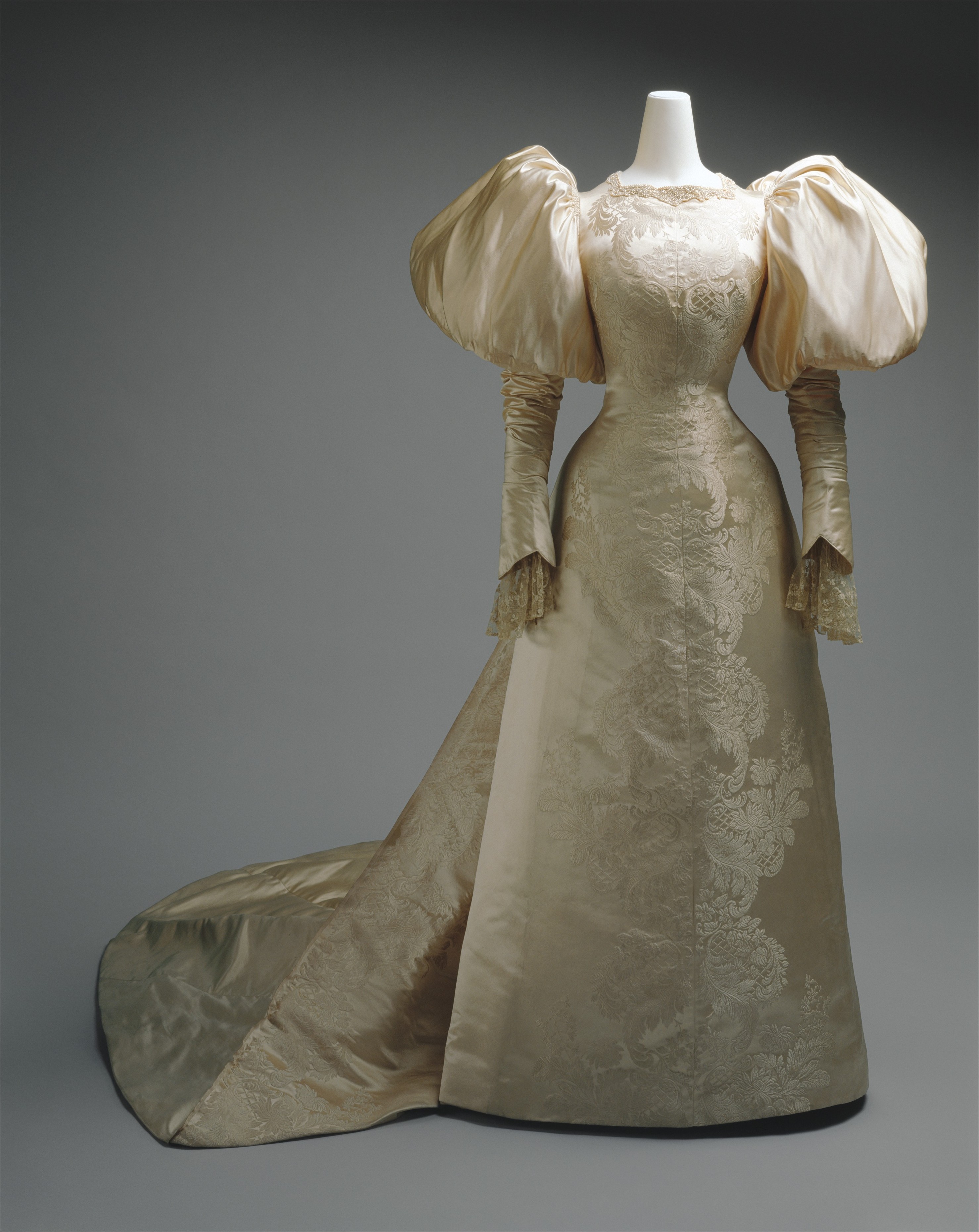 House of Worth silk and pearl wedding dress from 1896, shown frontally with a long train.